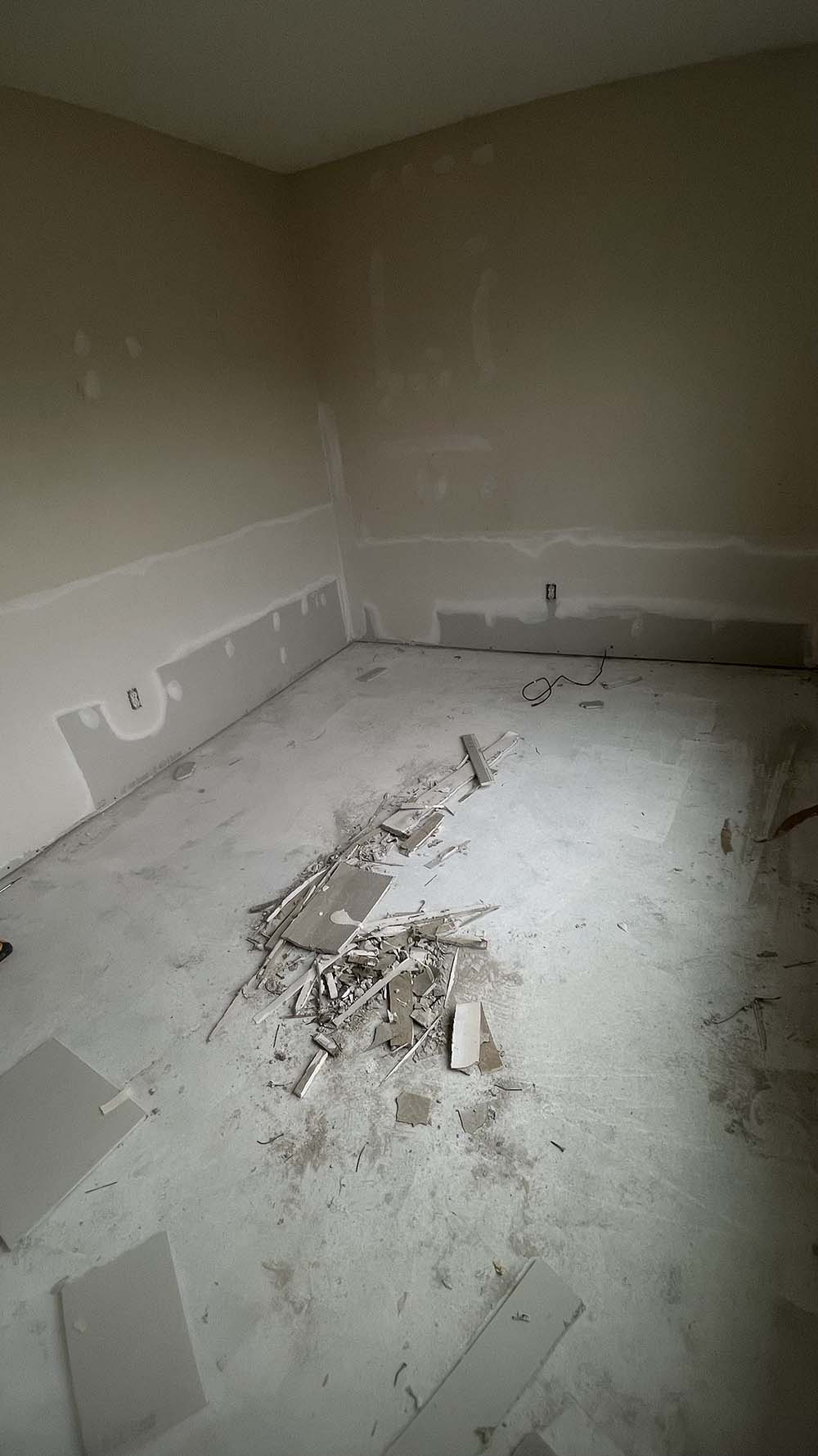 Floor-to-wall mudding pass across repaired flood cuts in Cedar Falls bedroom
